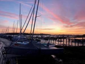 a group of boats docked in a marina at sunset at Itchenor Sailing Club in Chichester