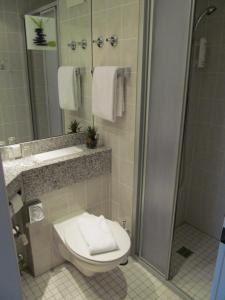La salle de bains est pourvue de toilettes, d'un lavabo et d'une douche. dans l'établissement Hotel A2, à Schopsdorf