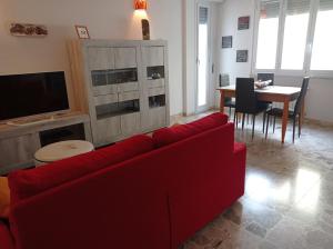 sala de estar con sofá rojo y mesa en ROBY house en Savona