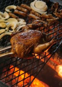 un pollo en una parrilla con un montón de comida en KAMPUNG KOPI CAMP en Pujungan