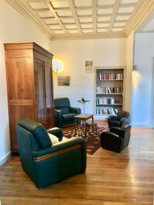 - un salon avec des chaises et une étagère dans l'établissement Le Relais Dunois de Napoléon, à Châteaudun