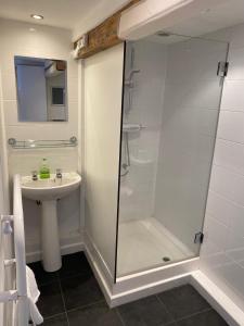 uma casa de banho com um chuveiro e um lavatório. em Itchenor Sailing Club em Chichester