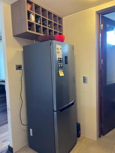 a stainless steel refrigerator in a kitchen next to a door at PUCON HOUSE - Lake Access & Near Ski Center in Pucón