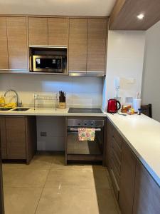 a kitchen with a stove and a microwave at PUCON HOUSE - Lake Access & Near Ski Center in Pucón