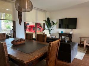 a dining room with a table and a black couch at PUCON HOUSE - Lake Access & Near Ski Center in Pucón