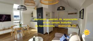 Una cocina y una sala de estar con un sofá y una mesa. en Klif w Mechelinkach, en Mechelinki