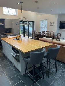 cocina con mesa de madera y algunas sillas en The House on the Common, en Coity