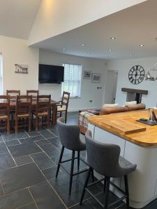 a kitchen and dining room with a table and chairs at The House on the Common in Coity