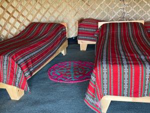 En eller flere senge i et værelse på Rima Yurt Camp at Song Kol lake