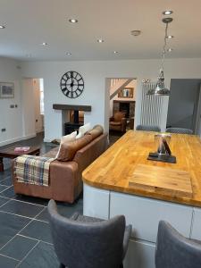 uma sala de estar com uma mesa e um sofá em The House on the Common em Coity