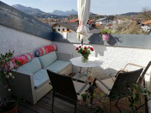 un sofá en un balcón con mesa y sillas en 3-Zi Atelierdachwohnung mit Bergblick Seenähe und 2 Loggia, en Bernau am Chiemsee