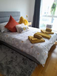 1 cama con almohadas, toallas y ventana en Fistral beach apartment en Newquay
