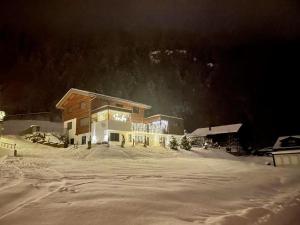 domek narciarski na śniegu w nocy w obiekcie Alpenzauber Apartment Montafon w mieście St. Gallenkirch