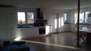 a kitchen with white cabinets and a table in a room at Ferienwohnung Zur Alten Gärtnerei in Hürtgenwald