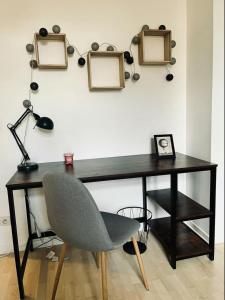 een bureau met een stoel en enkele foto's aan de muur bij Appartement avec terrasse Salle de sport et 3 chambres in Metz