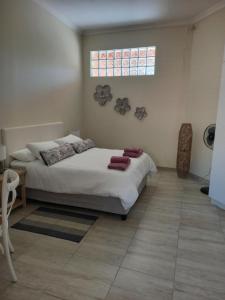 Schlafzimmer mit einem Bett und einem Fenster in der Unterkunft Bottle Brush Place WITH SOLAR in Roodepoort