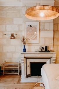 a bedroom with a fireplace and a large light fixture at B&B Maison Rosa in Bordeaux