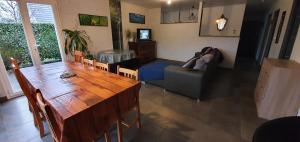 a living room with a couch and a table at 1 Chambre privative avec bureau et cuisine dans maison 105 m2 Montfaucon in Montfaucon