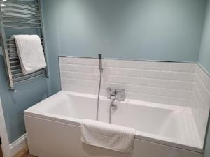 a white bath tub in a bathroom with a window at The Granary in Llanddeiniol +34 photos