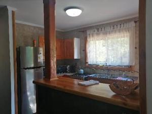 cocina con encimera de madera y nevera en Casa Country Pucón en Pucón