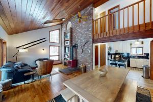 a living room with a wooden table and a brick wall at The GingerBreck House in Breckenridge