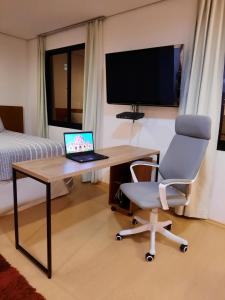 a room with a desk with a laptop and a chair at Studio Mercure Hotel Moema - Av. Jamaris 100 in Sao Paulo