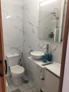 een witte badkamer met een toilet en een wastafel bij Alfa Omega (VALLE-LUZ) in Puerto de la Cruz