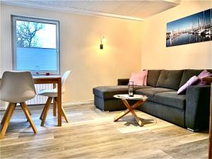 a living room with a couch and a table at Ferienhaus Till & Lotte in Börgerende-Rethwisch