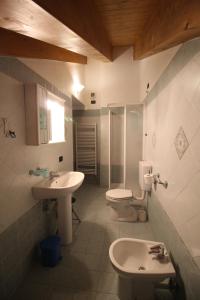 a bathroom with two sinks and a toilet and a shower at Residence Aquila - Mono Corno Vitello in Brusson