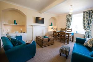 a living room with a blue couch and a table at White Swan Cottage in Alnwick