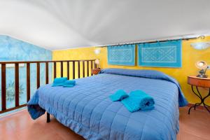 een slaapkamer met een blauw bed met blauwe kussens erop bij Gli Ulivi Palau - La Zirichelta in Palau