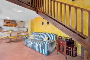 a living room with a couch and a staircase at Gli Ulivi Palau - La Zirichelta in Palau