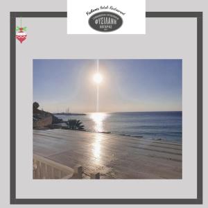 a picture of a beach with the sun in the sky at Fisilanis Beachfront Hotel in Logaras