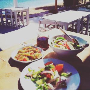 a table with three plates of food on it at Fisilanis Beachfront Hotel in Logaras