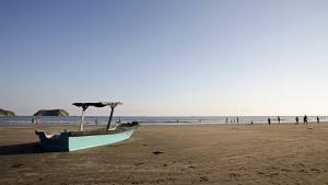 un barco en la playa con gente en el agua en Hotel Giada, en Sámara