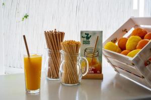 a table with a glass of orange juice and a box of fruit at Fisilanis Beachfront Hotel in Logaras