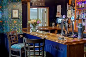 a bar with two chairs and a counter with a mirror at The Grange at Oborne in Sherborne