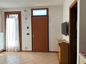 a room with a door with a window and a television at La Roggia in Thiene