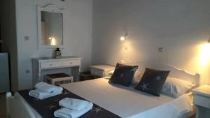 a bedroom with a bed with two towels on it at Fisilanis Beachfront Hotel in Logaras