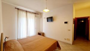 a bedroom with a bed and a large window at Cocos Park Ischia in Ischia
