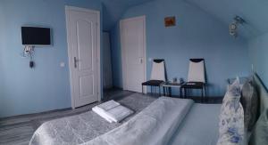 a blue bedroom with a bed and two tables at Casa Terzea in Râşnov