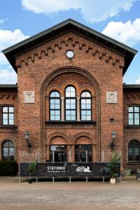 a red brick building with a clock on it at Stationen in Ystad