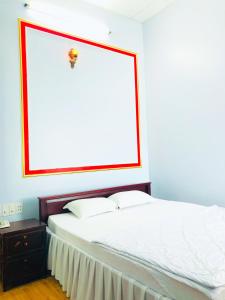 a bedroom with a white bed with a large window at KHÁCH SẠN ĐẾ VƯƠNG in Cao Lãnh