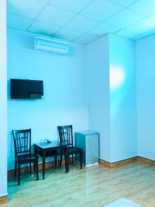 Zimmer mit 2 Stühlen, einem Tisch und einer blauen Wand in der Unterkunft KHÁCH SẠN ĐẾ VƯƠNG in Cao Lãnh