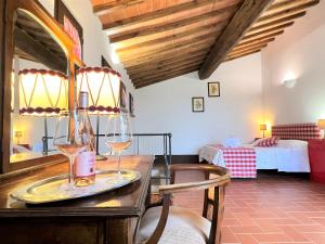 モンテリッジョーニにあるFattoria Lornano Wineryのワイングラス付きのテーブルが備わる客室です。