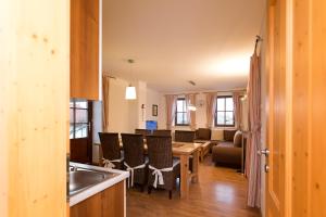 eine Küche und ein Wohnzimmer mit einem Tisch und Stühlen in der Unterkunft Ferienapartments Meixner in Eisenberg an der Pinka