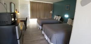 um quarto de hotel com duas camas e uma televisão em The anchor hotel em Myrtle Beach
