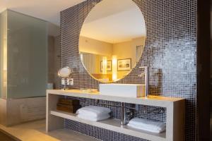 
a bathroom with a mirror, sink, and bathtub at Radisson Blu São Paulo in São Paulo
