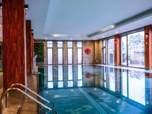 a swimming pool in a building with a large window at Hotel Europa Starachowice in Starachowice