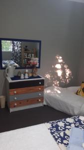 una camera con due letti e un comò con specchio di Campbell Stays a Kestell